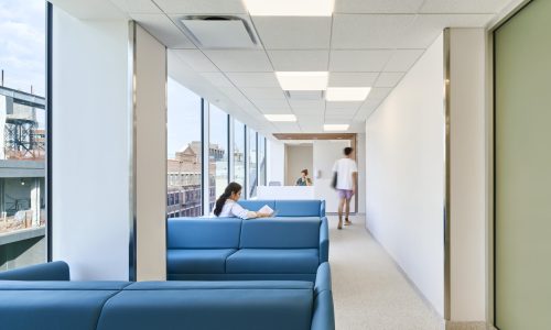 Blue couches in a hallway lit by natual light
