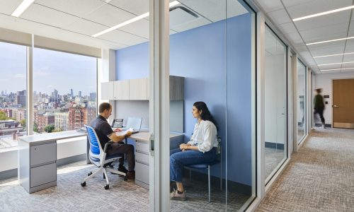 Two people talking in a naturally lit blue room