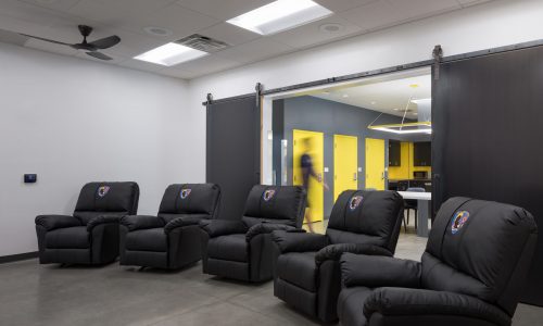 The entertainment room in Clark County Fire Station 61 in Las Vegas, NV features comfortable chairs. Note the barn doors leading to the kitchen.