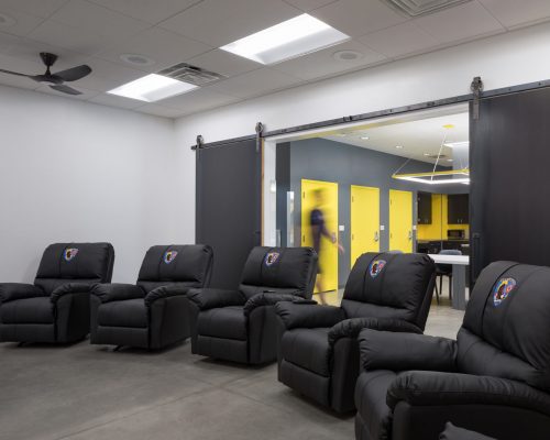 The entertainment room in Clark County Fire Station 61 in Las Vegas, NV features comfortable chairs. Note the barn doors leading to the kitchen.