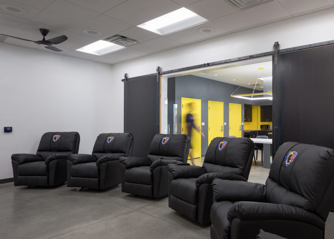 The entertainment room in Clark County Fire Station 61 in Las Vegas, NV features comfortable chairs. Note the barn doors leading to the kitchen.