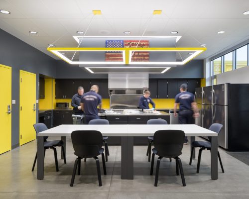 The kitchen and dining area inside Clark County Fire Station 61 in Las Vegas, NV features a large island work area and a large cooking area as well as a large table for meetings and meals. Each shift has its own pantry and refrigerator.