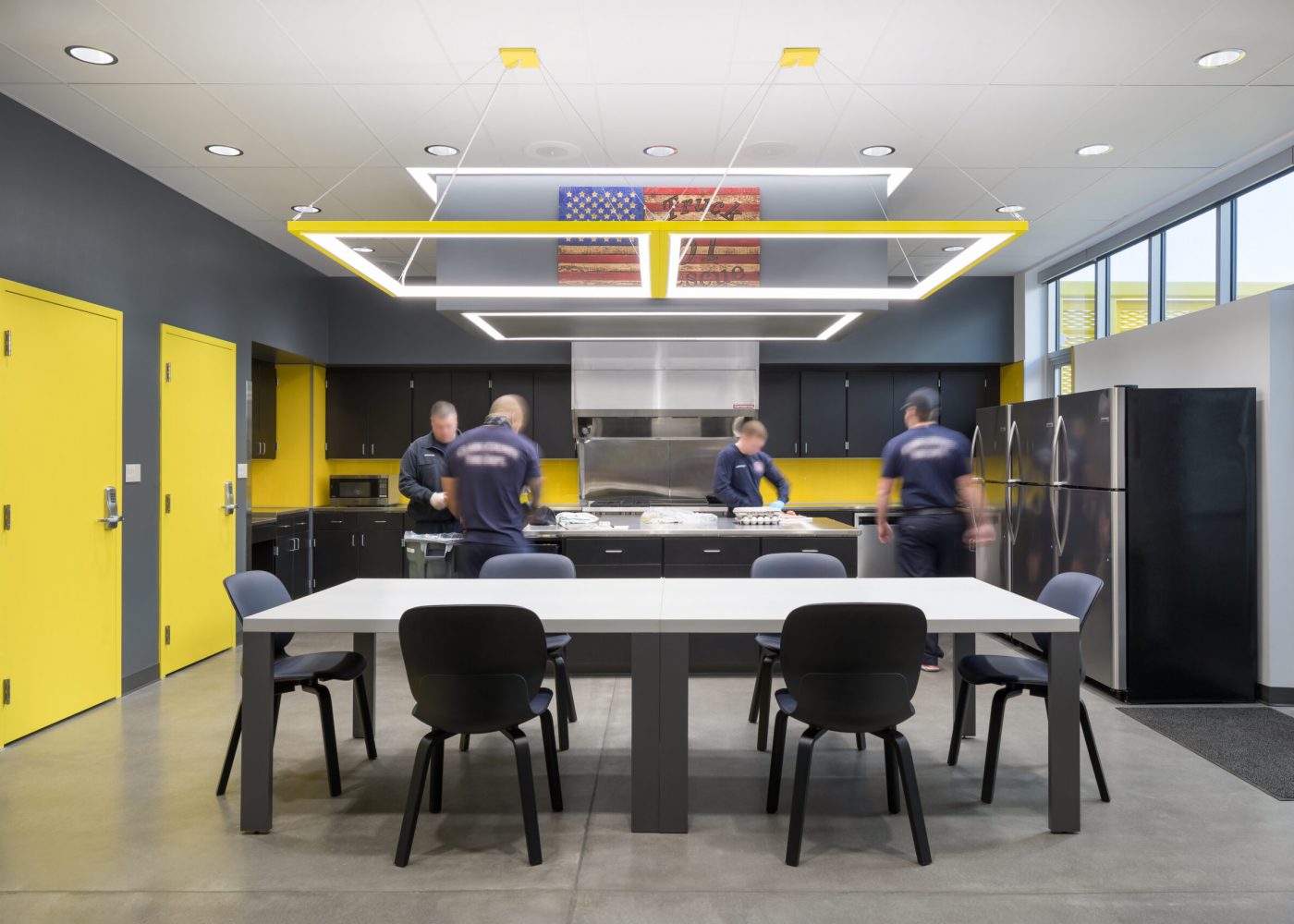 The kitchen and dining area inside Clark County Fire Station 61 in Las Vegas, NV features a large island work area and a large cooking area as well as a large table for meetings and meals. Each shift has its own pantry and refrigerator.