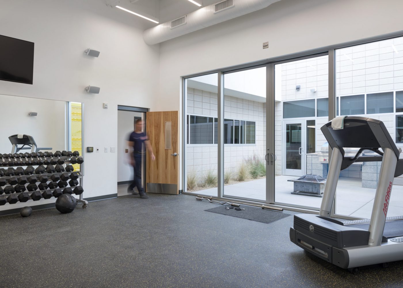 The fitness room at Clark County Fire Station 61 in Las Vegas, NV. The fitness room features sliding glass doors out to the grill area, which is also accessible via the kitchen.
