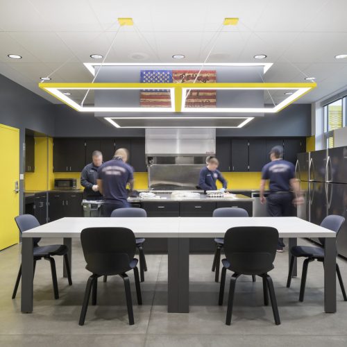 The kitchen and dining area inside Clark County Fire Station 61 in Las Vegas, NV features a large island work area and a large cooking area as well as a large table for meetings and meals. Each shift has its own pantry and refrigerator.