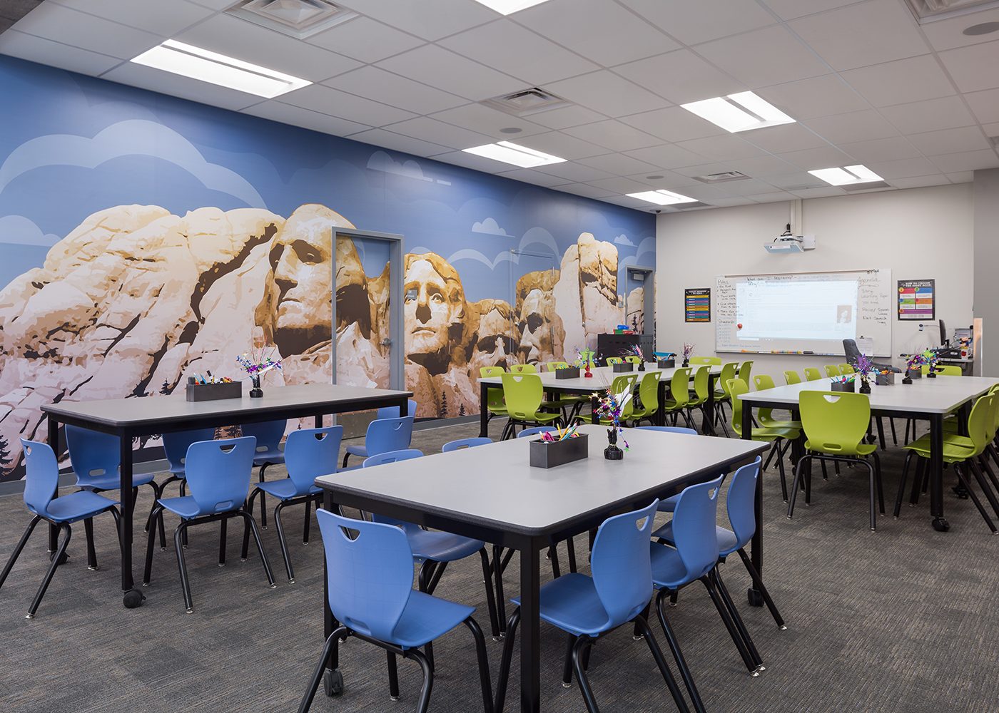 Tables in the library at Jenkins Elementary School in Las Vegas, NV are arranged in front of a large wall mural of Mount Rushmore.