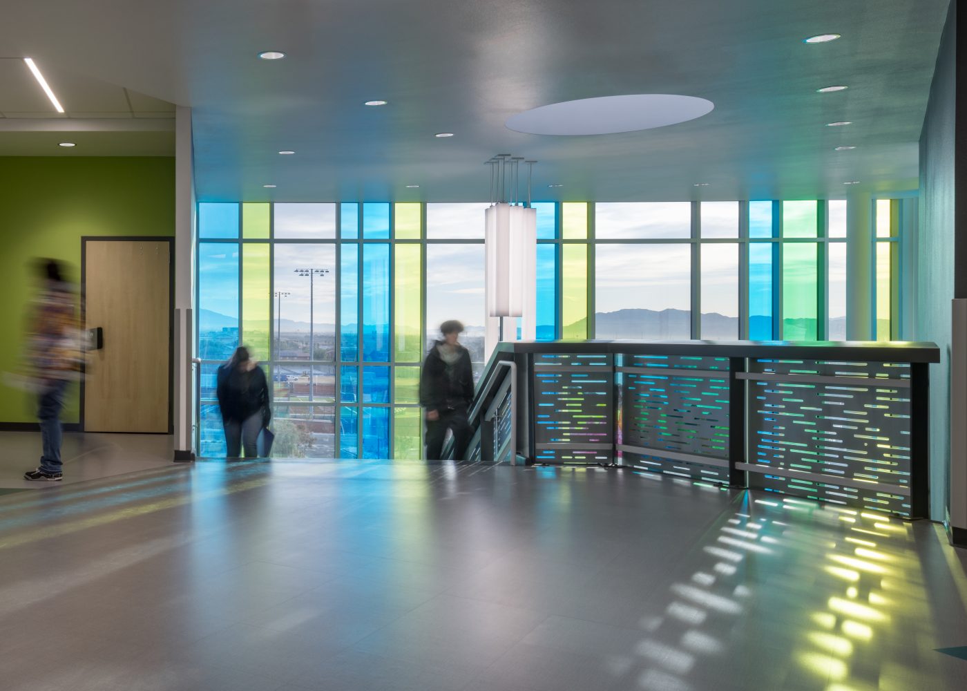 Students coming up the staircase with large windows behind. Northeast Career Technical Academy, a technical high school in North Las Vegas, NV.
