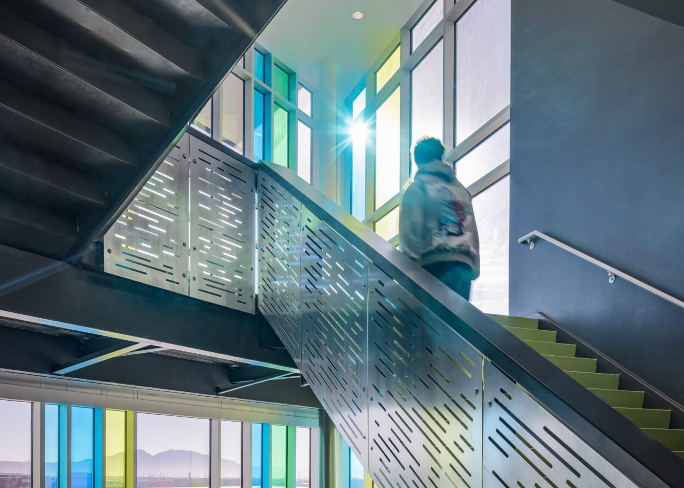 Students coming up the staircase with large windows behind. Northeast Career Technical Academy, a technical high school in North Las Vegas, NV.